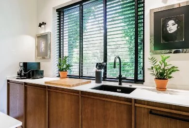 Jasne blaty w kontraście do frontów z ciemnego drewna w kuchni