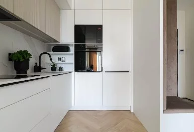 Minimalistyczna kuchnia z przeszkloną witryną na kieliszki i elegancką zabudową