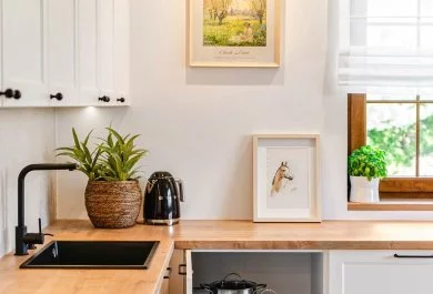 Zabudowa narożna białej kuchni z drewnianym blatem