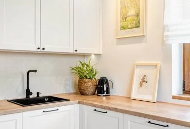 Strefa zlewu przy oknie w białej kuchni klasycznej