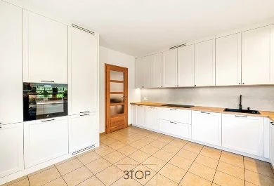 Klasyczna biała kuchnia z drewnianym blatem i zlewem