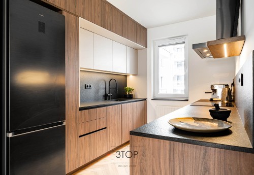 Nowoczesna kuchnia z drewnianymi frontami i czarnymi detalami