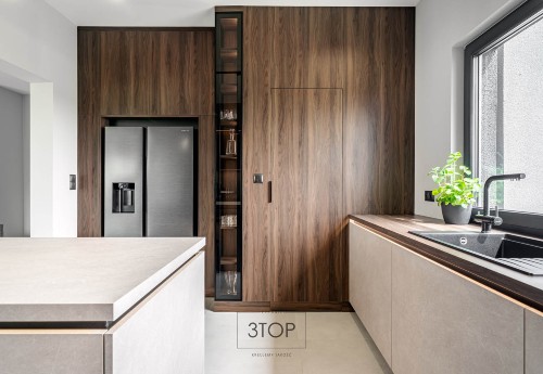 Nowoczesna kuchnia z wyspą i zabudową w drewnie